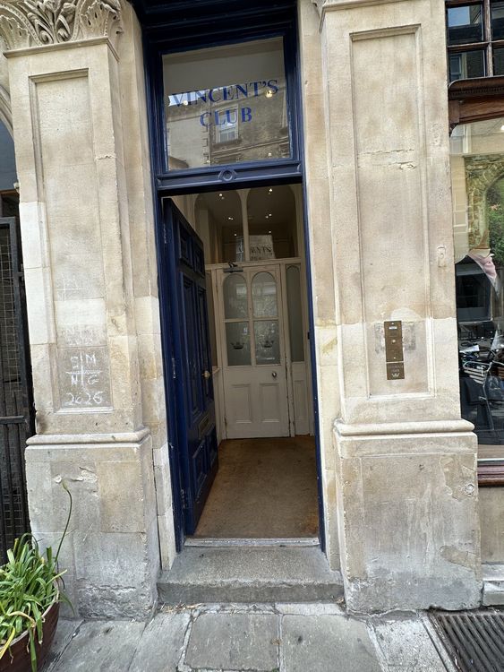 The open street door of Vincent's Club, with the club name in the fanlight above and the inner glazed door beyond.